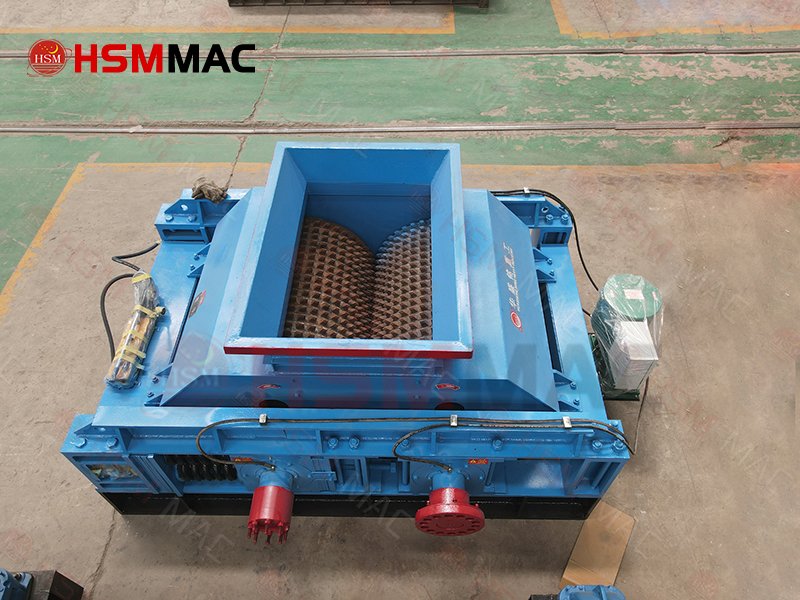 How does the double toothed roller crusher handle sticky, high-moisture, or high-mud materials without clogging?